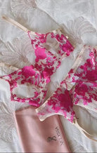 Floral lingerie set with a pink pouch on a textured fabric background
